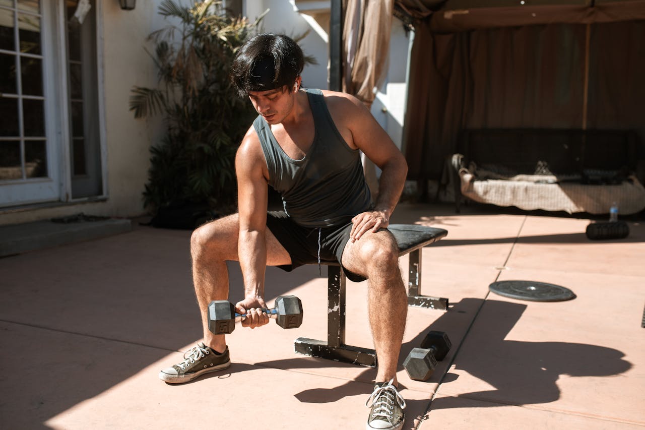 A man performing dumbbell curls outdoors, emphasizing fitness and active lifestyle.